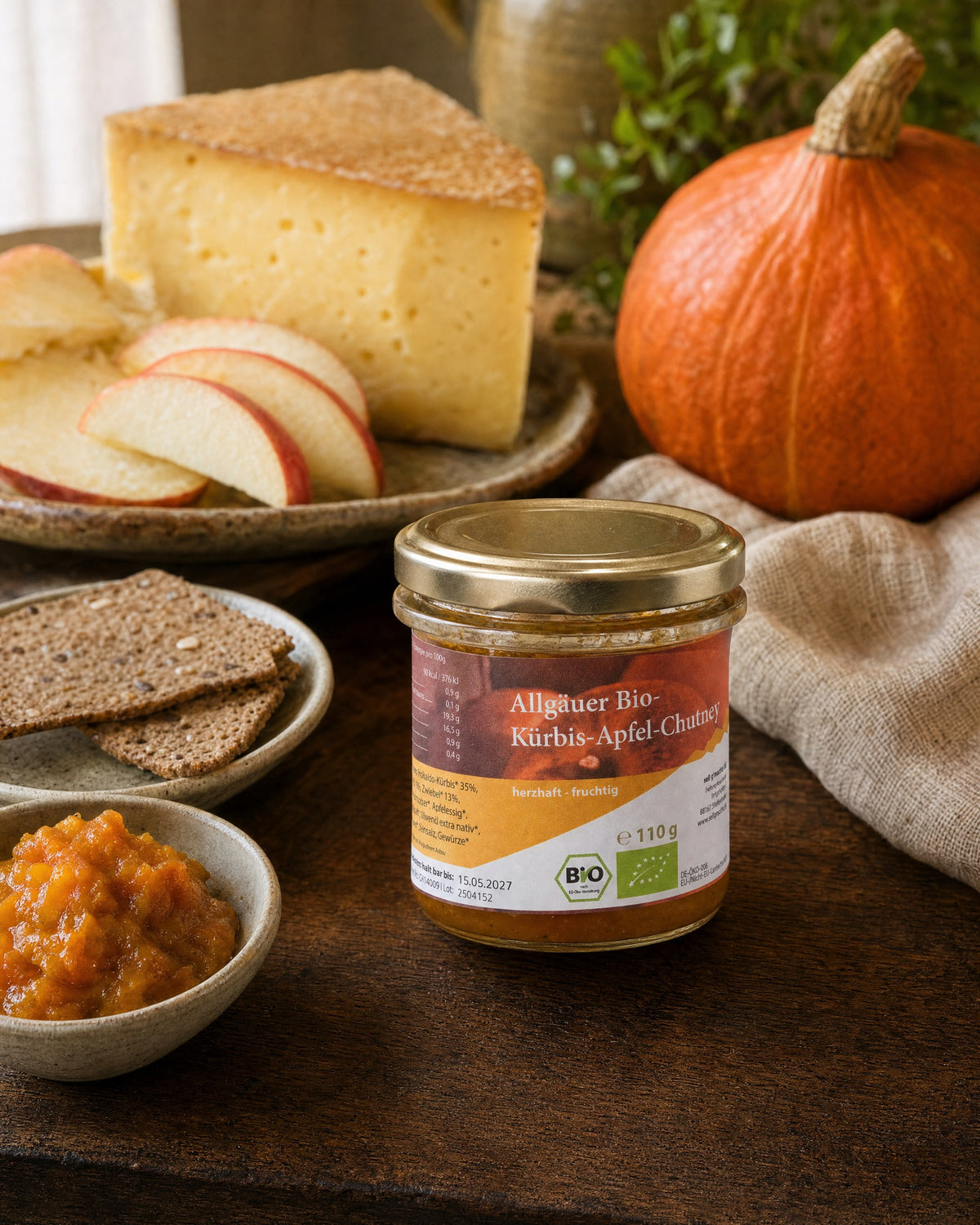 sell g'machts Allgäuer Bio Kürbis-Apfel Chutney auf einem Käsebrett mit Bergkäse, Apfelspalten, Knäckebrot und Hokkaido-Kürbis